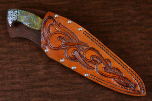 "Malaka" fine custom handmade knife, sheathed view in hand-engraved CPM 154CM powder metal technology stainless steel, T4 deep cryogenically treated, bolsters of hand-engraved 304 stainless steel, Plasma agate and Nephrite Jade gemstone handle, hand-carved leather crossdraw sheath with stainless steel hardware